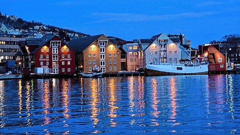 Idylle pur am Hafen in Tromsö. Hier spiegeln sich die teils historischen Fischerhäuser im Wasser des Hafens.
