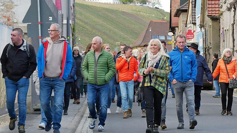 Gästeführerin Theresia Schlier (vorne, 2. von rechts) führte die Teilnehmerinnen und Teilnehmer des siebten „Escherndorfer Sinneszaubers“ durch das Winzerdorf zu fünf Weingütern im Dorf.