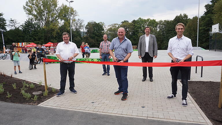 Eröffnung des 'Funpark 4 Seasons'. Bürgermeister Georg Seiffert (Mitte), der stellvertretende Landrat Josef Demar (links) und Alexander Zeller von der Regierung von Unterfranken (rechts) beim durchschneiden des roten Absperrbandes. Mit im Bild Pastoralreferent Stephan Tengler (zweiter von links) und der evangelische Pfarrer Oliver Englert (zweiter von rechts).