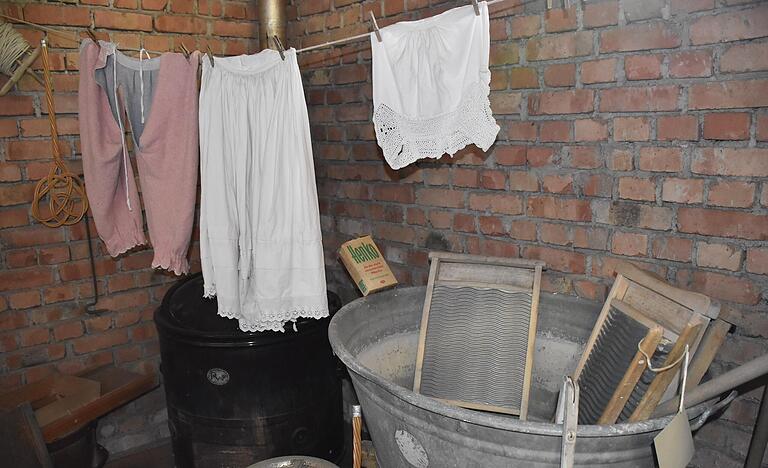 Um die Welt der Mode von einst komplett darzustellen, gehört auch die weniger prachtvolle Seite, der Waschtag, dazu. Die hochwertigen Stoffe aus Samt und Seide dürften dabei weniger mit 'Stömpfer' Waschbrett und Kernseife in Berührung gekommen sein, sondern die robustere Alltagstracht, die auch im Stall oder auf dem Acker getragen wurde. In den Räumen der Geldersheimer Trachtensammlung kann man bewundern, wie das einst ausgesehen hat, wenn die 'Unterröck' zum Trocknen aufgehängt wurden.