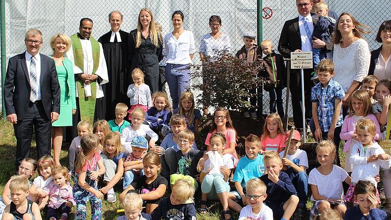 Eine Blutbuche soll künftig am Geiselwinder Sportlatz wachsen. Vorsitzender Oliver Hofrichter spendete und pflanzte sie nach dem Festgottesdienst zur Feier des 70-jährigen Bestehens des TSV mit den Kindern sowie den Ehrengästen.