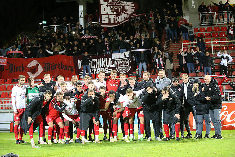 Gruppenbild mit Fan-Unterstützung: Das Team der Würzburger Kickers nach dem Pokal-Sieg gegen Vilzing.