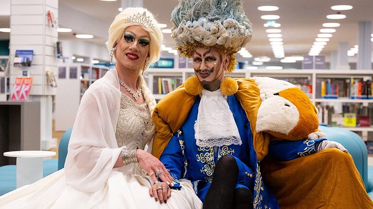 Dragqueen Vicky Voyage (l) und Dragking Eric BigClit.jpeg       -  Dragqueen Vicky Voyage (links) und Dragking Eric BigClit halten in der Münchner Stadtteilbibliothek eine Lesung für Kinder.