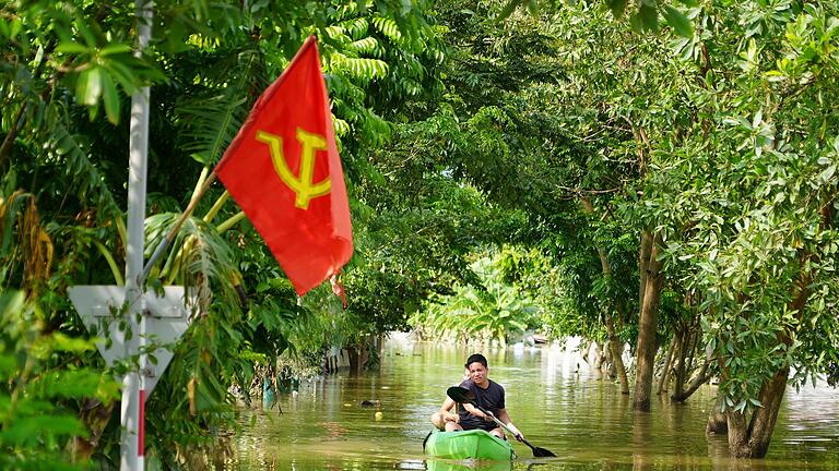 Taifun &bdquo;Yagi&rdquo; - Vietnam       -  Ein Mann paddelt in der Nähe von Hanoi durch das Hochwasser.