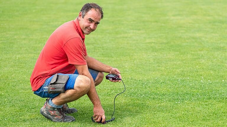 Dominik Schmitt misst die Feuchtigkeit im Rasen. Er ist Platzwart und erster Vorsitzender des Fußball-Bezirksligisten TSV Trappstadt - zudem Greenkeeper im Golfclub Maria Bildhausen.