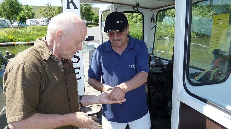 Bald 25 Dienstjahre: Der Nordheimer Fährmann Edmund Gürsching (rechts) gibt einem Fahrgast das Wechselgeld.