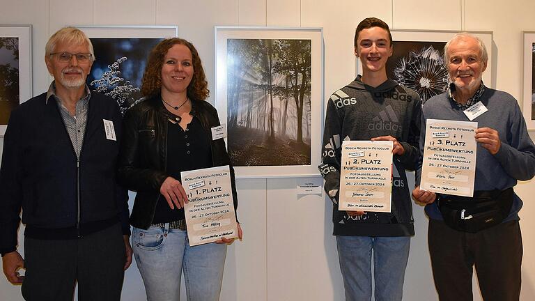 Gewinner mit Siegerfoto (von links): Vorsitzender des Bosch-Rexroth-Fotoclubs, Albert Köckemann, Siegerin Tina Höfling, ihr Foto 'Sonnenstrahlen im Nebelwald', Zweitplatzierter Johannes Sauer und Dritter Alfons Herr.