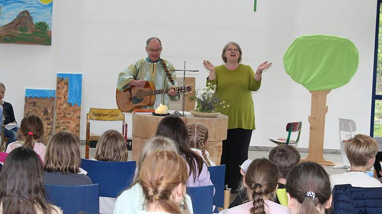 Gemeindereferent Bernd Müller und Pfarrerin Kirsten Müller-Oldenburg singen mit den Kindern beim Bibeltag.