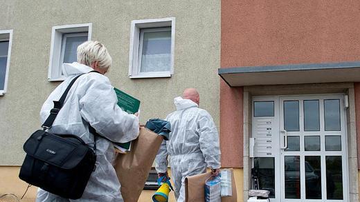 Ermittler       -  Ermittler auf dem Weg zu einem Mehrfamilienhaus im Oderbruchort Golzow, wo ein totes Baby gefunden worden war. Foto: Patrick Pleul