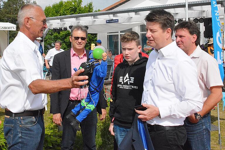 Innenstaatssekretär Sandro Kirchner war Schirmherr der Europäischen Meisterschaft im Modellfallschirmzielspringen am Flugplatz des Aero Clubs Bad Königshofen. Von Thomas Boxdörfer vom Deutschen Modellfliegerverband (DMFV) ließ er sich anhand eines Modells das einmal genau erklären. Innenstaatssekretär Sandro Kirchner war Schirmherr der Europäischen Meisterschaft im Modellfallschirmzielspringen am Flugplatz des Aero Clubs Bad Königshofen. Von Thomas Boxdörfer vom Deutschen Modellfliegerverband (DMFV) ließ er sich anhand eines Modells das einmal genau erklären.