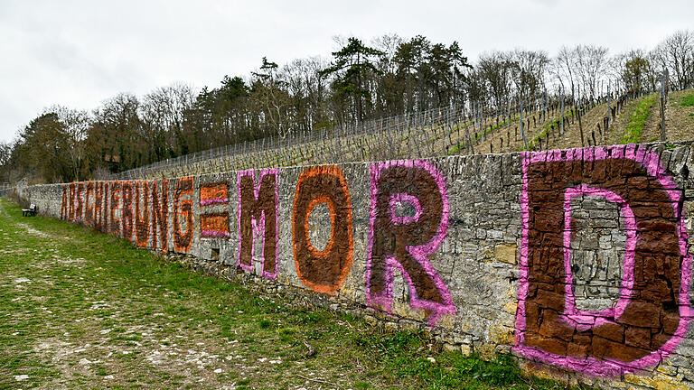 'Abschiebung=Mord', dieser Schriftzug unbekannter Aktivisten steht auf einer Mauer in der Weinlage am Würzburger Stein. Die Kriminalpolizei ermittelt. 'Abschiebung=Mord', dieser Schriftzug unbekannter Aktivisten steht auf einer Mauer in der Weinlage am Würzburger Stein. Die Kriminalpolizei ermittelt.