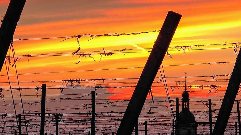 Farbenfroher Sonnenuntergang &ndash; fotografiert von den Weinbergen aus mit dem Wiesenbronner Kirchturm im Blick.