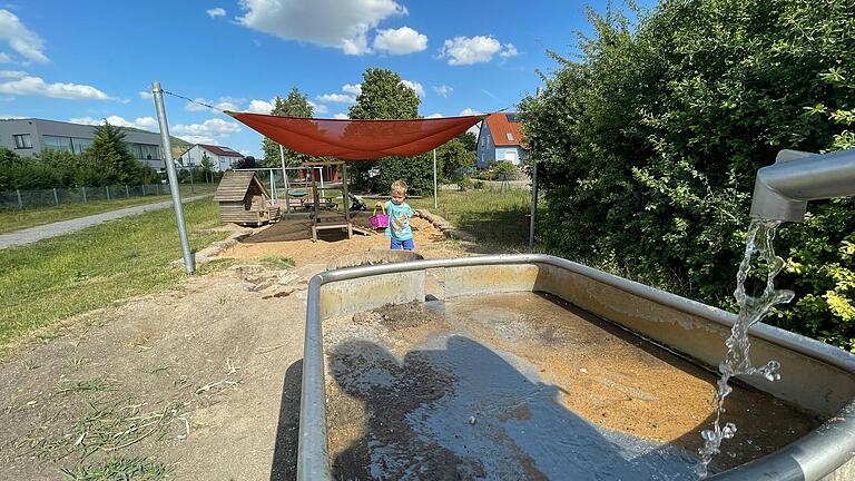 Auf dem Spielplatz im Iphöfer Baugebiet Hündlein gibt es eine Wasserpumpe, Becken und einen winzigen Bachlauf.