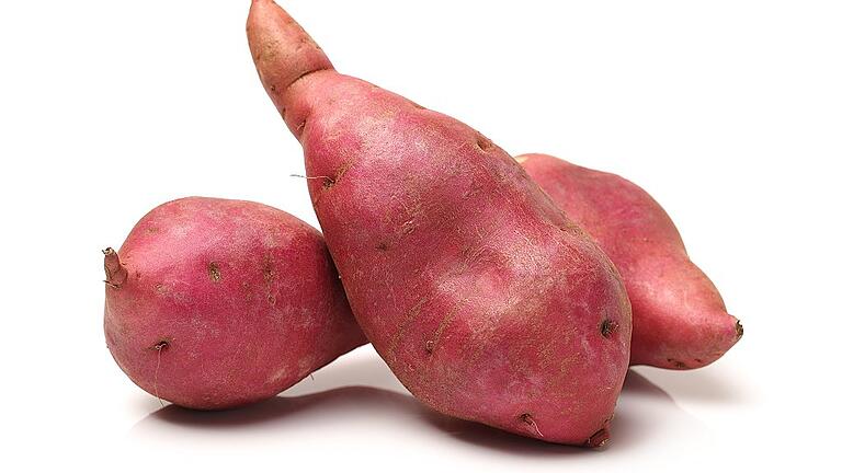 Sweet potatoes on a white background       -  Voll im Trend: die Süßkartoffel.