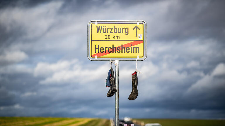 Ungewöhnliche Aktion an den Ortsschildern: Warum hängen Gummistiefel an den Schildern in Würzburg Stadt und Land?