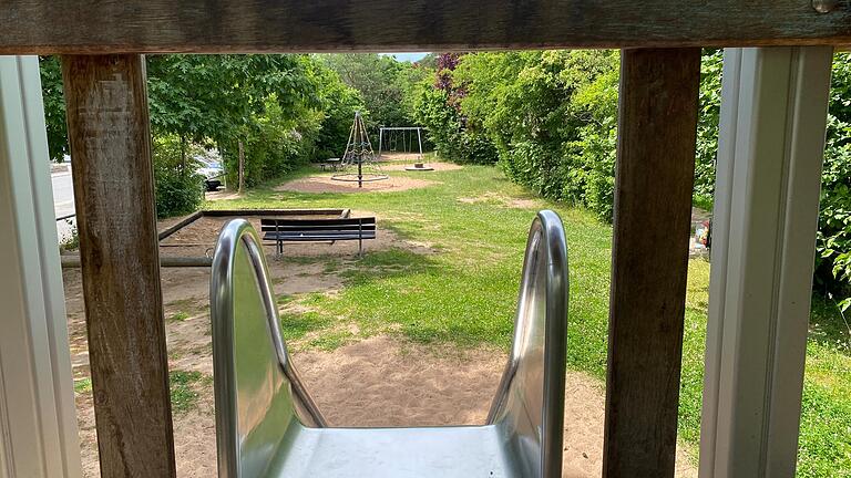 Ein Blick vom Rutschenturm des Spielplatzes Bayernstraße über das lang gezogene Areal mit viel nackter Erde zwischen den Wiesenflecken.