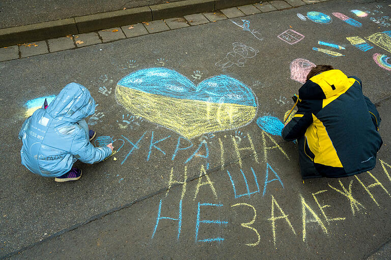 Ukrainische Flüchtlingskinder malen ein blau-gelbes Herz auf die Straße. Darunter steht: 'Unsere Ukraine ist unabhängig.' Ukrainische Flüchtlingskinder malen ein blau-gelbes Herz auf die Straße. Darunter steht: 'Unsere Ukraine ist unabhängig.'