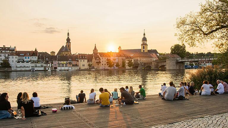 Die Sonnenuntergänge beim Kitzinger Stadtschoppen locken die Romantiker auf den Stadtbalkon am Main.