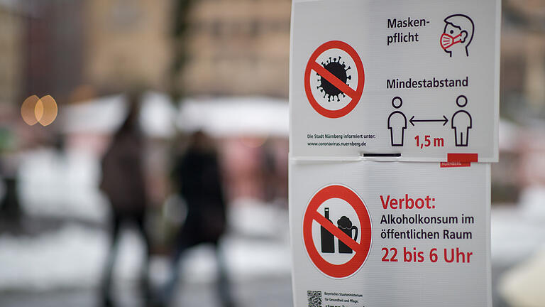 Ein Schild informiert Passanten auf dem Hauptmarkt in Nürnberg über die Maskenpflicht und weitere Corona-Verhaltensregeln. Ein Schild informiert Passanten auf dem Hauptmarkt in Nürnberg über die Maskenpflicht und weitere Corona-Verhaltensregeln. 
