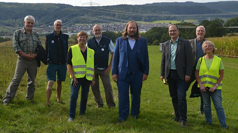 Anton Hofreiter (im blauen Anzug) informierte sich über das Bauprojekt B26n. Unser Bild zeigt ihn zusammen mit (von links) Wolfgang Weis, Torsten Ruf, Bärbel Imhof, Erwin Scheiner, Armin Beck, Gerhard Kraft und Mathilde Lembach am Romberg in Sendelbach. Im Hintergrund ist Wombach zu sehen.