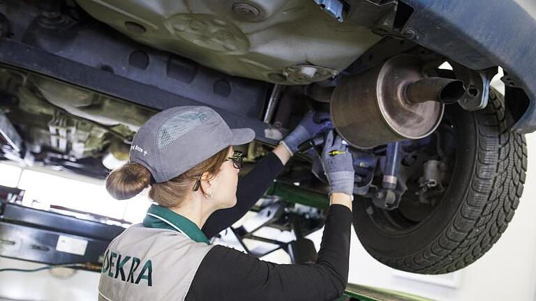 KFZ-Ingenieurin Stephanie Schneider kontrolliert in einer Stuttgarter Dekra-Werkstatt ein Auto. Bis Ende 2020 sollen von EU-Vorgaben «abweichende Anforderungen» zum Bestätigen der Messgenauigkeit von Prüfgeräten zulässig sein. Foto: Christoph Schmidt/Symbolbild       -  Regelmäßig muss jedes Auto durch die Hauptuntersuchung.