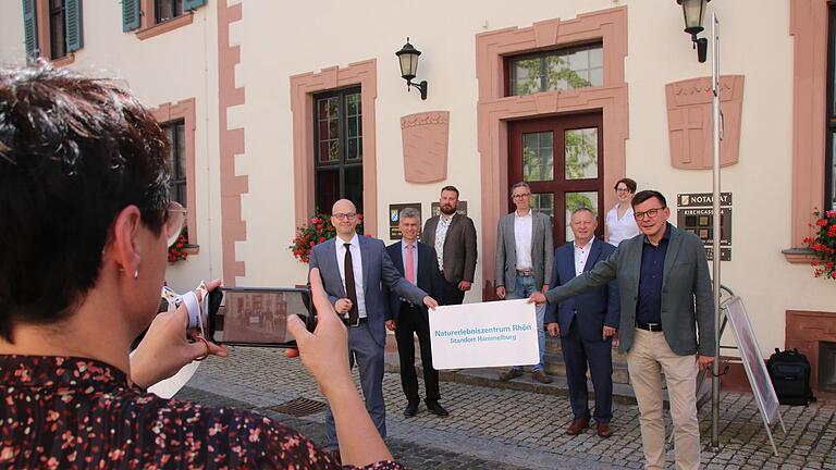 Gruppenbild von der offiziellen Eröffnung am Eingang zum Roten Schloss in Hammelburg: Der Bad Kissinger OB Dirk Vogel (links) und der Hammelburger Bürgermeister Armin Warmuth (rechts) halten das neue NEZ-Schild. Dahinter Abteilungsdirektor Bertram Eidel und Landrat Thomas Bold, auf der Treppe die Mitarbeiter Felix Papsch, Dr. Joachim Schneider und Lisa Graskamp. Foto: Ralf Ruppert - Gruppenbild von der offiziellen Eröffnung am Eingang zum Roten Schloss in Hammelburg: Der Bad Kissinger OB Dirk Vogel (links) und der Hammelburger Bürgermeister Armin Warmuth (rechts) halten das neue NEZ-Schild. Dahinter Abteilungsdirektor Bertram Eidel und Landrat Thomas Bold, auf der Treppe die Mitarbeiter Felix Papsch, Dr. Joachim Schneider und Lisa Graskamp. Foto: Ralf Ruppert Gruppenbild von der offiziellen Eröffnung am Eingang zum Roten Schloss in Hammelburg: Der Bad Kissinger OB Dirk Vogel (links) und der Hammelburger Bürgermeister Armin Warmuth (rechts) halten das neue NEZ-Schild. Dahinter Abteilungsdirektor Bertram Eidel und Landrat Thomas Bold, auf der Treppe die Mitarbeiter Felix Papsch, Dr. Joachim Schneider und Lisa Graskamp. Foto: Ralf Ruppert - Gruppenbild von der offiziellen Eröffnung am Eingang zum Roten Schloss in Hammelburg: Der Bad Kissinger OB Dirk Vogel (links) und der Hammelburger Bürgermeister Armin Warmuth (rechts) halten das neue NEZ-Schild. Dahinter Abteilungsdirektor Bertram Eidel und Landrat Thomas Bold, auf der Treppe die Mitarbeiter Felix Papsch, Dr. Joachim Schneider und Lisa Graskamp. Foto: Ralf Ruppert