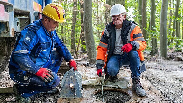 Ingenieur Ralf Richter von der DTM, einer Tochterfirma des TÜV Nord, misst an einer Bohrstelle in der Altertheimer Mulde (Lkr. Würzburg) mit einem Lichtlot, in welcher Tiefe Grundwasser vorhanden ist. Trifft das Maßband auf die Wasseroberfläche unter der Erde, leuchtet die Lampe.