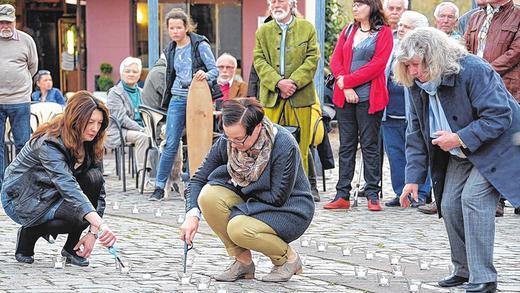 Gedenken an die Kriegstoten Gemündens: Jasna Blaic (v.l.), Edith Rützel und Edda Fischer beim Anzünden der 229 Kerzen.