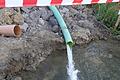 Ständig läuft die Pumpe: Das abgepumpte Wasser aus der Baugrube wird erst in ein Auffangbecken und dann in den benachbarten Bach geleitet.