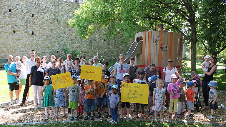 Mitarbeiter des städtischen Gartenamtes wie auch des Fachbereichs Jugend und Familie übergaben den neu gestalteten Spielplatz an der Heidingsfelder Stadtmauer bei einem kleinen Fest an die Kinder. Mit dabei Gartenamtsleiter Dr. Helge Bert Grob (4. v.li), Christiane Matzewitzki (5.v.li., Fachabteilung Kinder-, Jugend- und Familienarbeit), Marie-Luise Löchner vom Gartenamt (links hinter dem Schild „Danke“) und die Stadträte Eckhard Gunther Beck (7. v.li.), Christiane Kerner (8.v.li.), Heinz Braun (rechts daneben) und Karin Miethaner-Vent (Mitte links, hinter dem „Dankeschön“-Schild“). Foto: Sophia Scharf, Familienstützpunkt Kunterbunt Heidingsfeld Mitarbeiter des städtischen Gartenamtes wie auch des Fachbereichs Jugend und Familie übergaben den neu gestalteten Spielplatz an der Heidingsfelder Stadtmauer bei einem kleinen Fest an die Kinder. Mit dabei Gartenamtsleiter Dr. Helge Bert Grob (4. v.li), Christiane Matzewitzki (5.v.li., Fachabteilung Kinder-, Jugend- und Familienarbeit), Marie-Luise Löchner vom Gartenamt (links hinter dem Schild „Danke“) und die Stadträte Eckhard Gunther Beck (7. v.li.), Christiane Kerner (8.v.li.), Heinz Braun (rechts daneben) und Karin Miethaner-Vent (Mitte links, hinter dem „Dankeschön“-Schild“). Foto: Sophia Scharf, Familienstützpunkt Kunterbunt Heidingsfeld