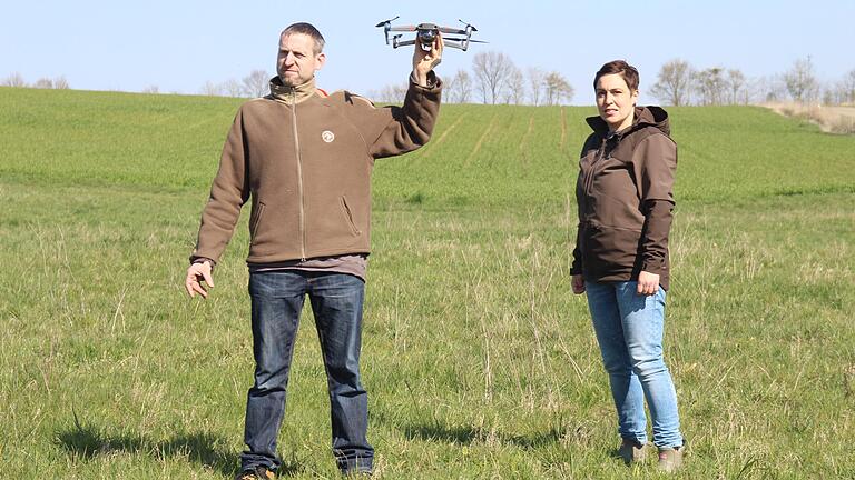 Joachim Heil, Vorsitzender der Jagdgenossenschaft Wülfershausen, erprobt gemeinsam mit Initiatorin Claudia Fella die neue Drohne, durch die Jungtiere gerettet werden sollen.