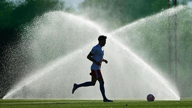 Abkühlung tut gut bei diesen Temperaturen, vor allem für alle, die Fußball spielen. Im Symbolbild läuft Jonas David vom Hamburger SV im Trainingslager in Spanien vor einem Wassersprenger vorbei. Aber auch in Unterfranken wurden in dieser Woche Temperaturen weit über 30 Grad gemessen.