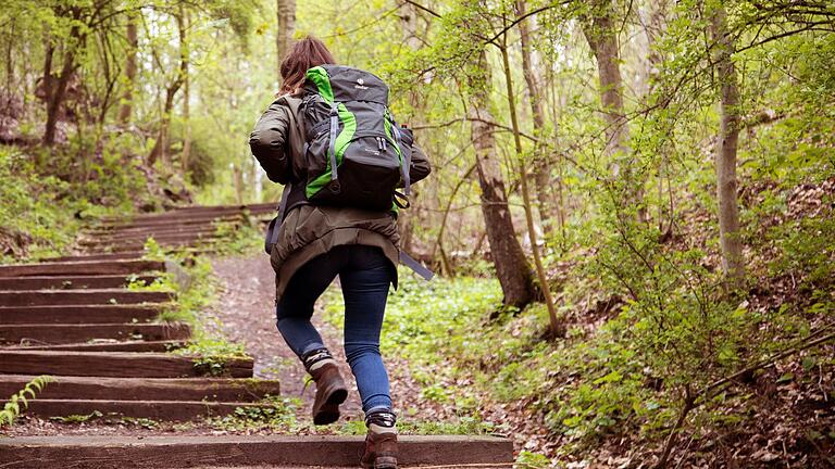 Frau mit Rucksack       -  Stufe für Stufe: Strecken, die bergauf führen, bedeuten zusätzlichen Trainingseffekt.