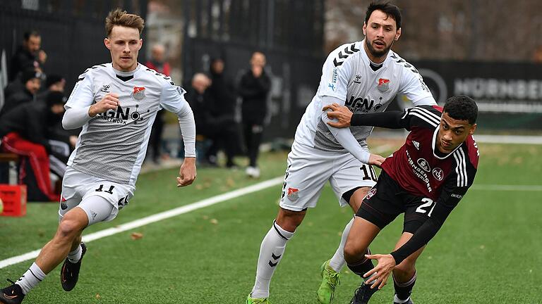 Leonard Langhans (links) und Timo Pitter (Mitte) vom TSV Aubstadt überlaufen Nathaniel Brown (rechts) vom 1. FC Nürnberg II.