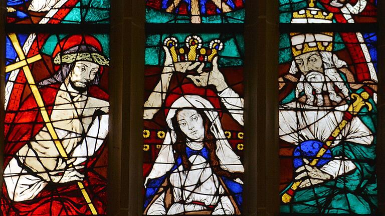 Das große Hauptfenster im Chorraum der Stadtpfarrkirche Bad Königshofen verweist auf das Fest Mariä Aufnahme in den Himmel und die Krönung Mariens.