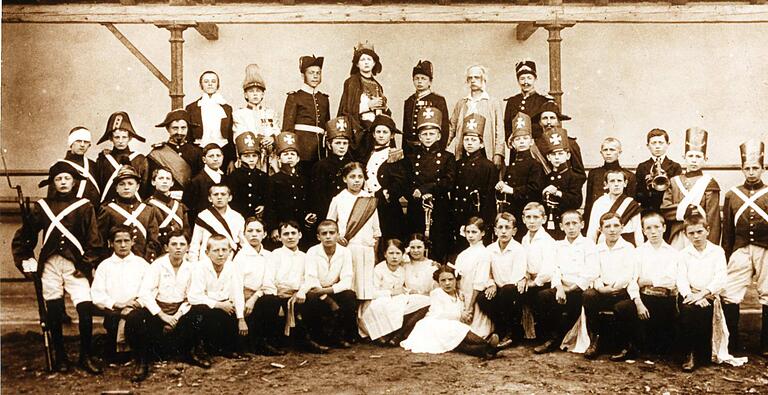 Aufführung 1915 (im Ersten Weltkrieg) eines patriotisches Stückes zur Erinnerung an die Zeit der Befreiungskriege gegen Napoleon 1812 bis 1815. Ein Teil der jungen Lohrer Darsteller trägt Uniformen, die an die Landwehr dieser Zeit erinnern sollen. Die späteren Land- und Bürgerwehren des 19. Jahrhundert waren ähnlich uniformiert.
