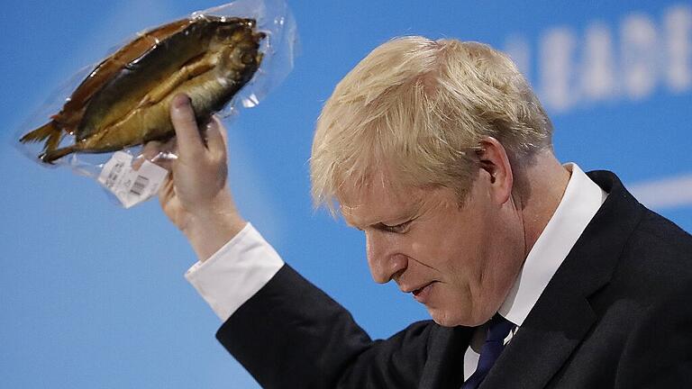 TOPSHOT-BRITAIN-EU-POLITICS-BREXIT-CONSERVATIVE       -  Wofür der Brexit lohnt: Boris Johnson bei seiner Rede vor den Konservativen mit einer englischen Fischspezialität.