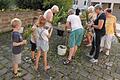 Mit großem Interesse verfolgten die Kinder das Binden von Kräutersträußchen beim Frauenbund Hofheim. Im Hintergrund&nbsp;Pfarrvikar Ninh.