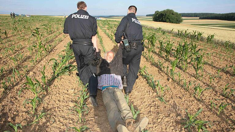 Ende Juni 2008 auf einem Feld bei Biebelried (Lkr. Kitzingen): Nach der Erstürmung und Zerstörung von Genmais-Pflanzen holen Polizisten 56 Aktivisten vom Feld – mitunter auch im Schlepptau.