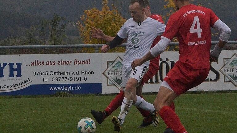 David Heuring (weißes Trikot) setzt sich gegen zwei Gegenspieler durch und erzielt hier die 1:0-Führung für die SG Urspringen-Sondheim/Rhön gegen den FV Rannungen/Pfändhausen/Holzhausen. Maximilian Bindrim (Nummer 4) kommt zu spät.