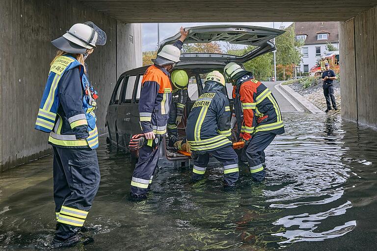 Hier befreien Feuerwehrleute einen Autofahrer aus einer Überschwemmung.