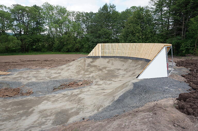 Neben dem asphaltierten Pumptrack wird es auch einen Dirttrack geben. Die ersten Holzelemente für Sprünge und die Steilwandkurve wurden bereits aufgebaut.