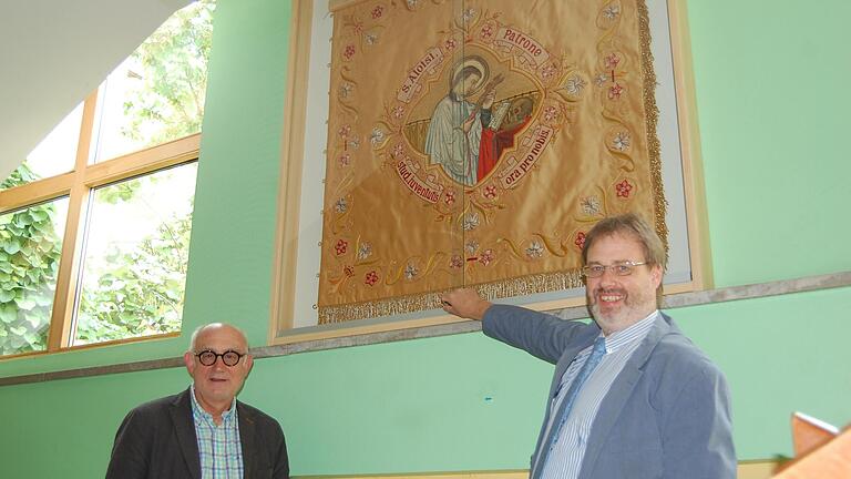 Dr. Manfred Gerlach von den Freunden des Frobenius-Gymnasiums und Schulleiter Dr. Matthias Ludolph freuen sich über die restaurierte Schulfahne.