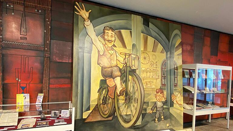 Auf dem Bild ist Philipp Moritz Fischer zu sehen auf seinem Fahrrad, daneben sein Sohn Friedrich, der mit einer Kugel in der Werkstatt in der Obere Straße 8 in Schweinfurt spielt. Das Bild ist eine Reproduktion eines Gemäldes von Alexander Ziegler und im Vorraum des Stadtarchivs im Rückert-Bau zu sehen. Auf dem Bild ist Philipp Moritz Fischer zu sehen auf seinem Fahrrad, daneben sein Sohn Friedrich, der mit einer Kugel in der Werkstatt in der Obere Straße 8 in Schweinfurt spielt. Das Bild ist eine Reproduktion eines Gemäldes von Alexander Ziegler und im Vorraum des Stadtarchivs im Rückert-Bau zu sehen.