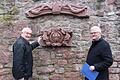 Hubert Schuster (links) und Bruno Schneider (rechts)  an der Stadtmauer vor den gesicherten historischen Bauteilen von Alt-Gemünden.