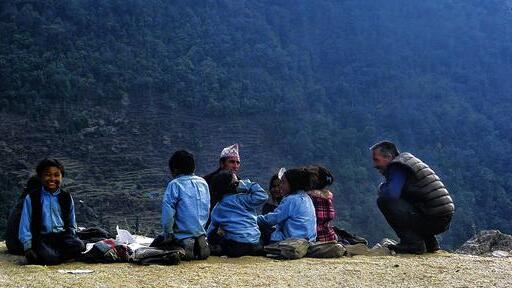 Unter freiem Himmel: Peter Piesch (rechts) aus Randersacker besucht eine Unterrichtsstunde der Grundschule von Simigaun im Rolwaling-Gebiet (Nepal) &ndash; im Freien auf dem Boden sitzend, auf über 2000 Metern Höhe. Mittendrin sitzt der Lehrer.