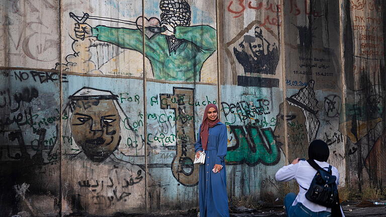 Ramadan in den Palästinensischen Autonomiegebieten.jpeg       -  Palästinensische Mädchen machen Fotos an der Trennmauer zwischen Israel und den Palästinensergebieten.