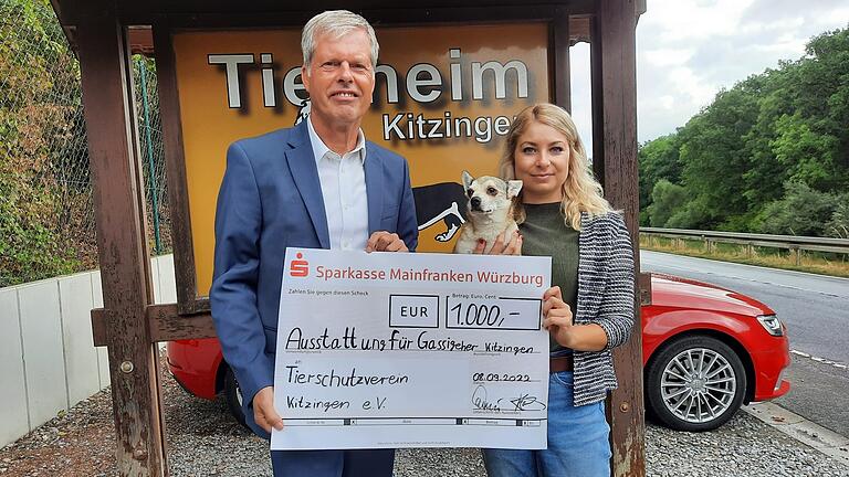 Christian Blachnik (Sparkasse Kitzingen) übergibt Sharon Hawkins vom Kitzinger Tierschutzverein eine 1000-Euro-Spende. Damit soll einheitliche Kleidung für die Gassi-Geher angeschafft werden.