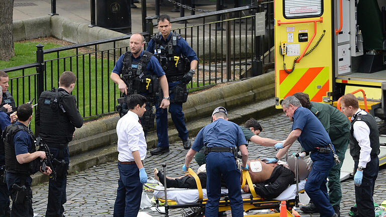 Schüsse nahe britischem Parlament       -  Rettungskräfte behandelnd eine verletzte Person in der Nähe des britischen Parlaments in London.