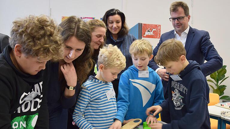 Vier Schüler erarbeiten sich einen Sortieralgorithmus mit verschiedenen schweren Zylindern und einer Balkenwaage. Unterstützt und motiviert werden sie von (von links): FELI-Lab-Mitarbeiterin Kristina Prümer, Ute Schmid, Dorothee Bär und Christian Lange.